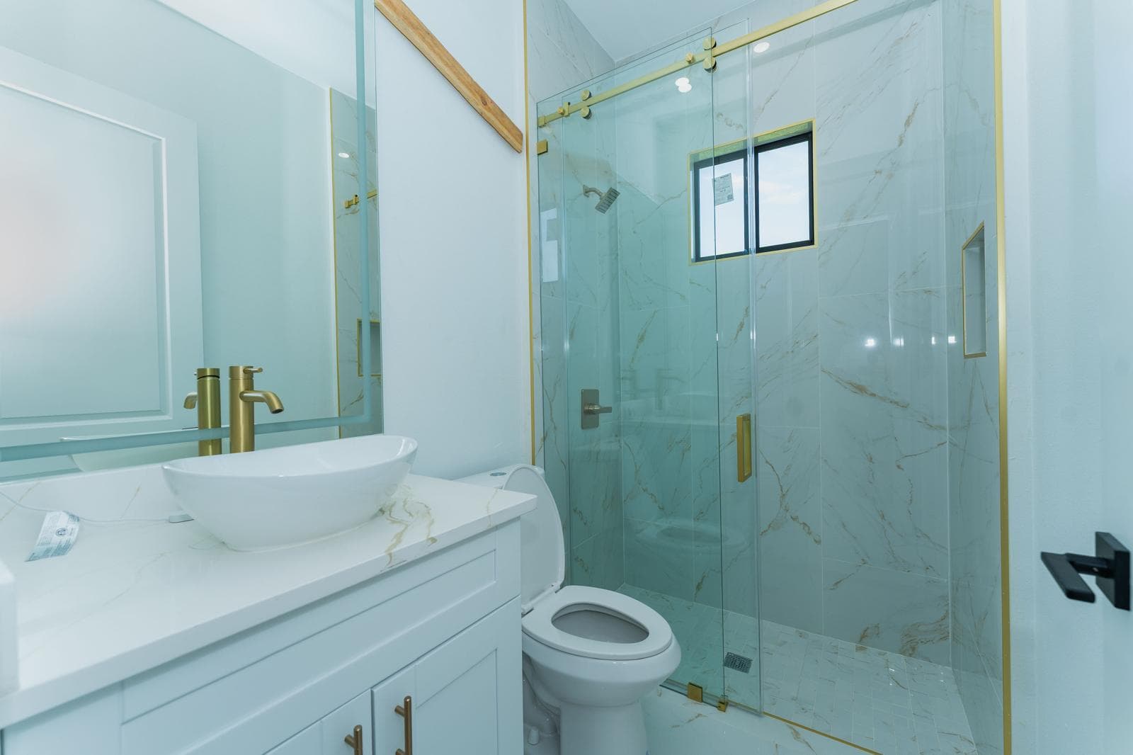 Luxury bathroom remodel with marble tile and gold fixtures